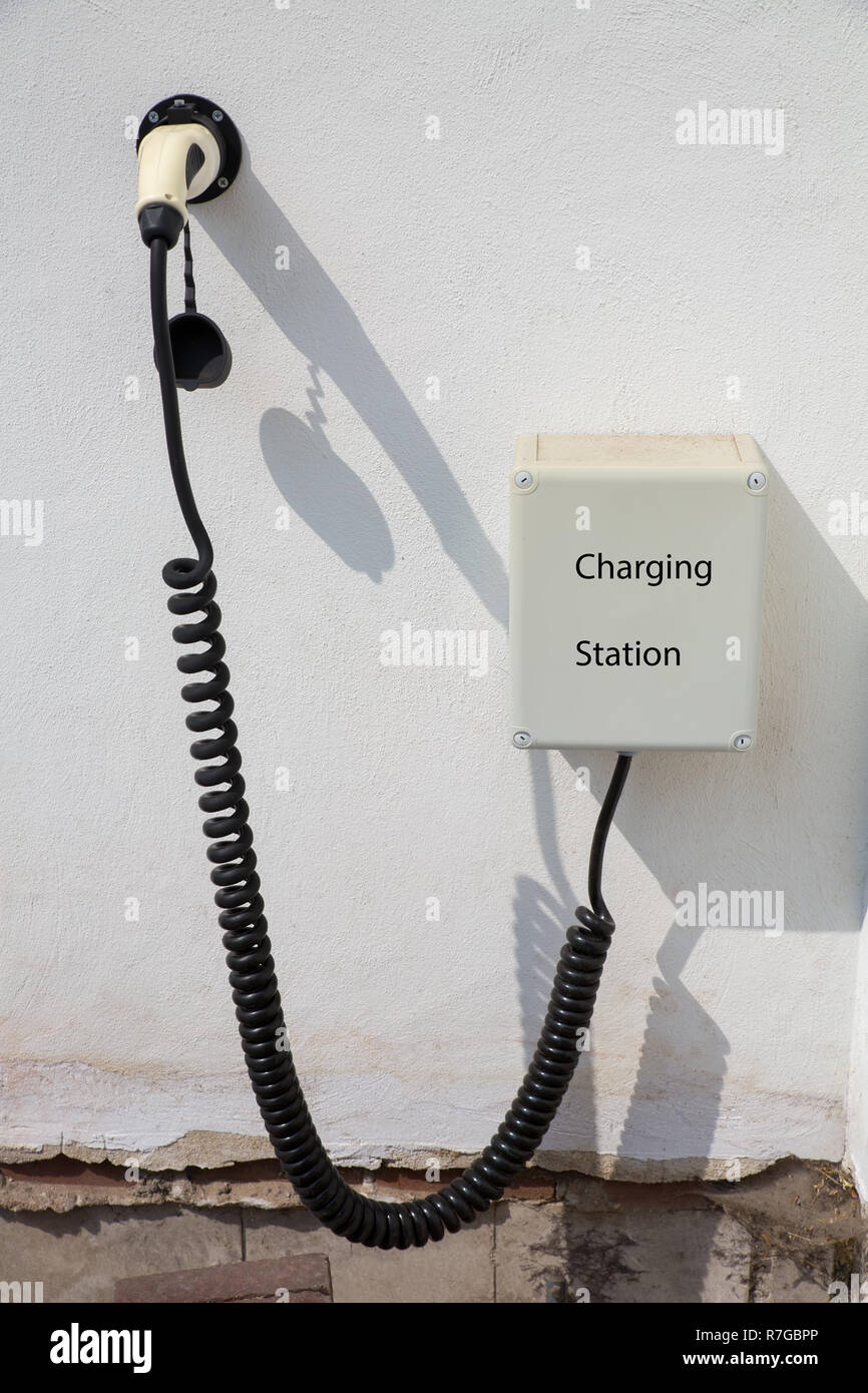Point de recharge pour voiture électrique sur le mur blanc de la chambre Banque D'Images