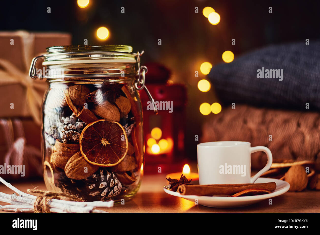 Tasse de café, pommes de pin, des oranges séchées et garland phares sur fond sombre. Hygge ou décorations accueil chaleureux Banque D'Images