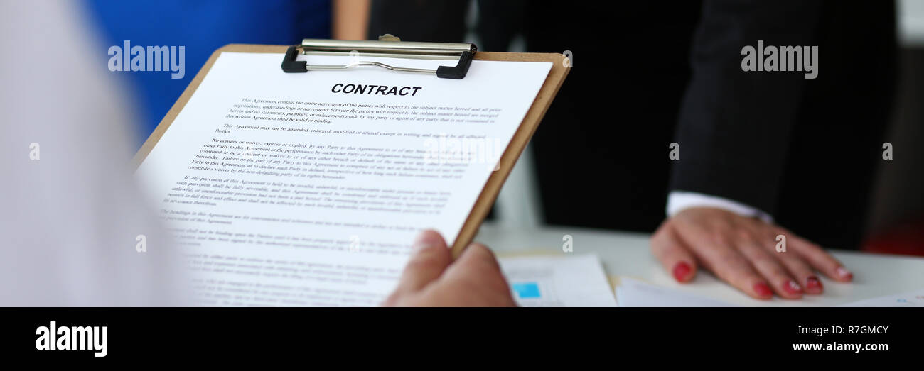 Maintenez le bras masculin formulaire de contrat clippée sur pad Banque D'Images