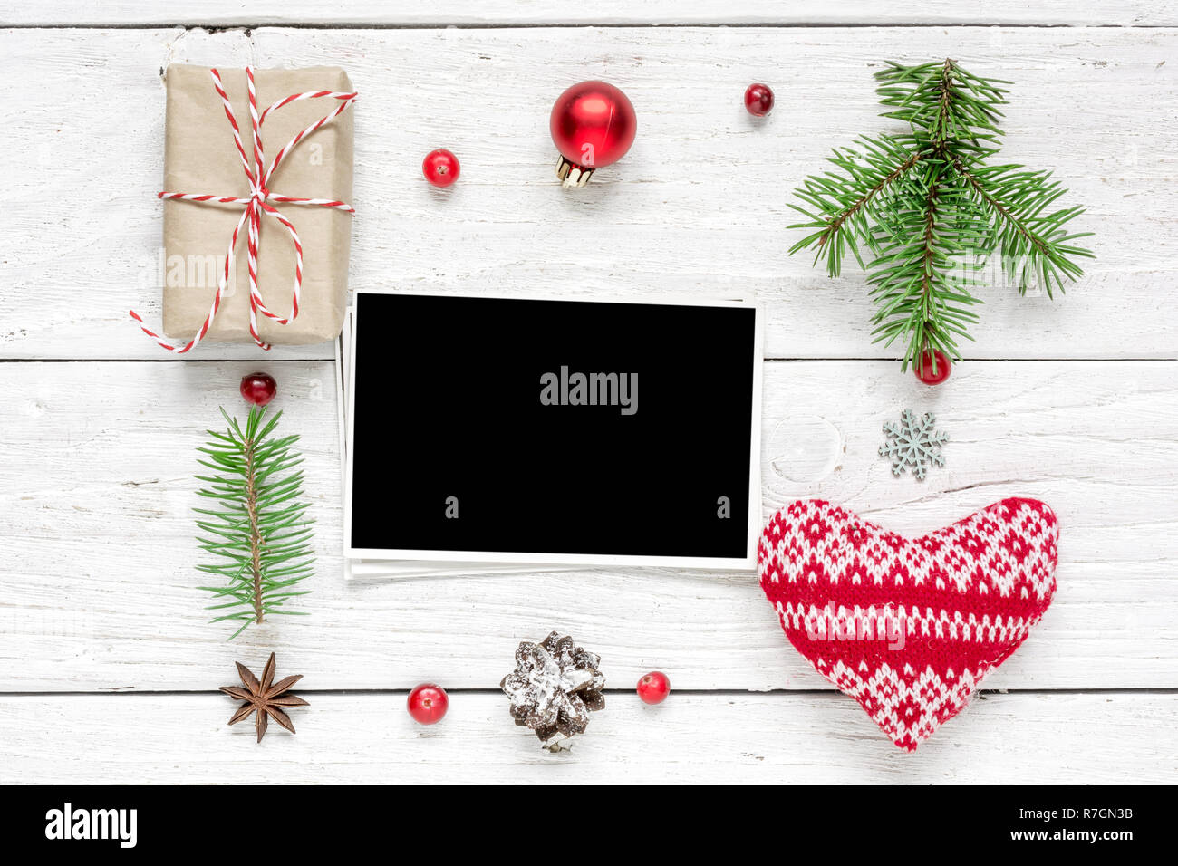 Carte photo vierge noël dans cadre fait de branches de sapins, décorations et coffrets cadeaux over white background. maquette. Télévision. Vue de dessus Banque D'Images