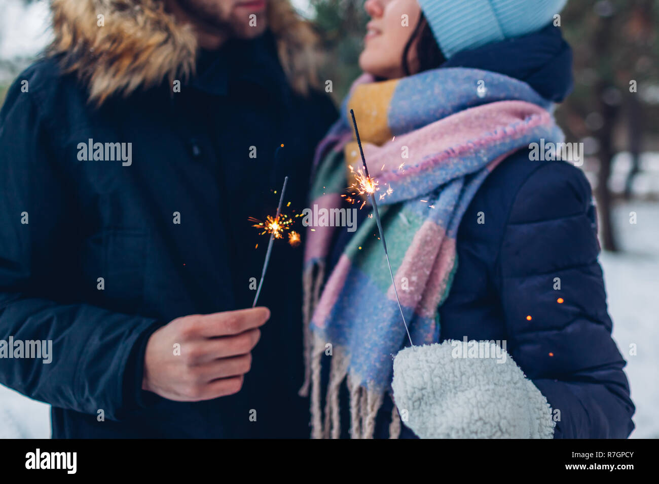 Beau couple aimant cierges brûlant dans la forêt d'hiver. Noël et Nouvel an concept. Close up Banque D'Images