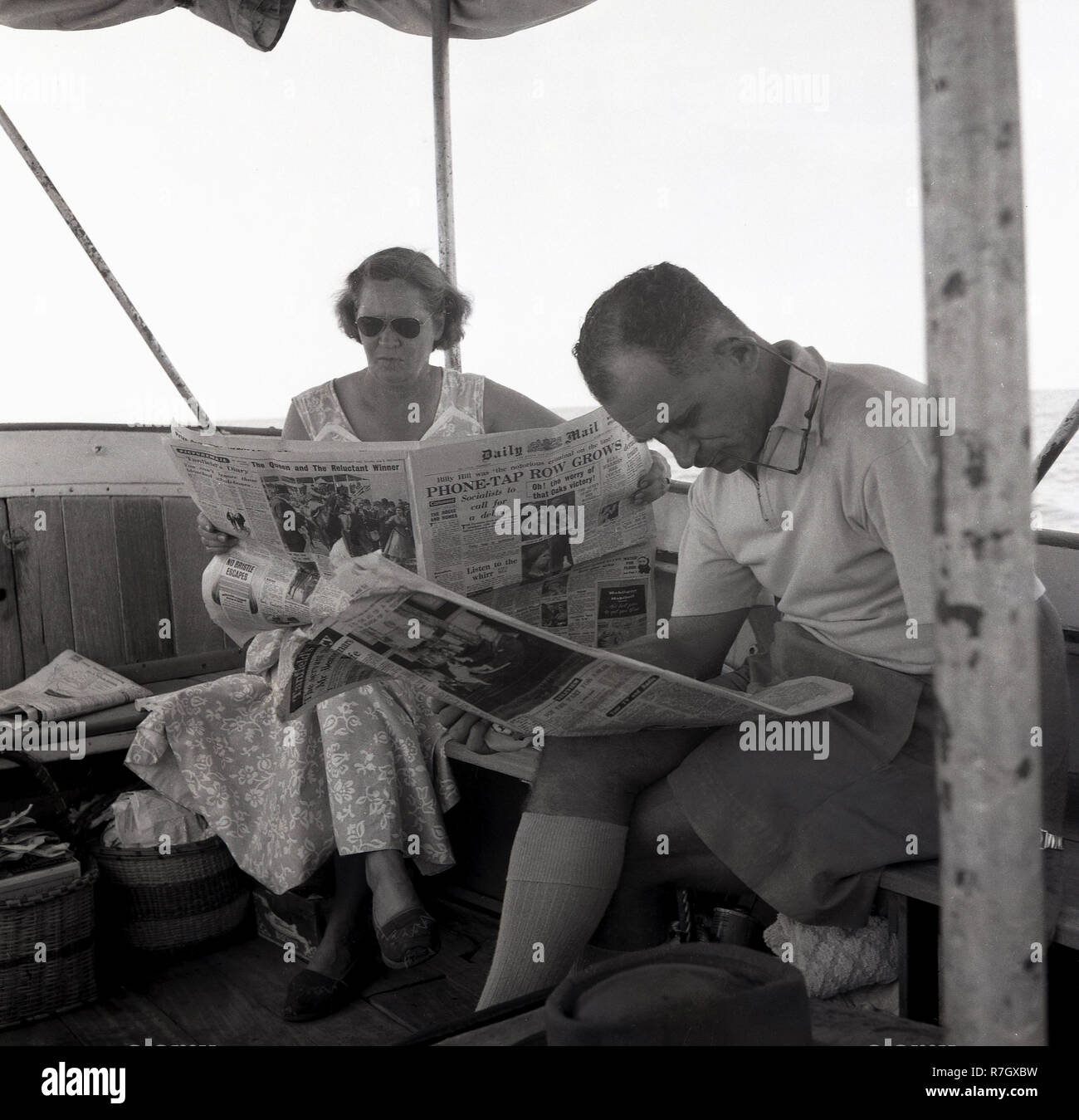 Années 1950, un homme wpman et assis sur un bateau sur le lac Victoria, en Ouganda, lire un journal, le Daily Mail. Le quotidien britannique en cette époque était un journal de qualité et serait envoyé à colonies et protectorats britanniques outre-mer, comme l'Ouganda était, avant que le pays est devenu indépendant en 1962. Banque D'Images