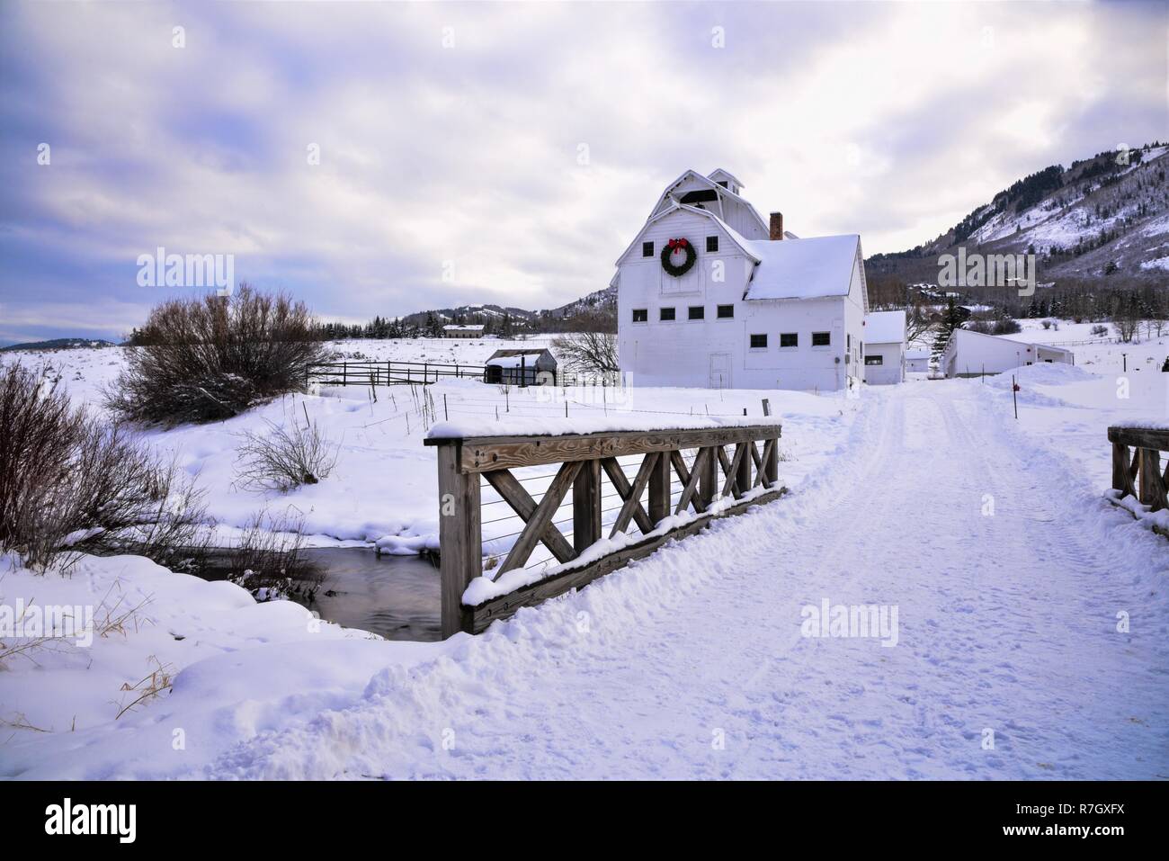 Grange Blanche avec couronne de Noël dans une prairie enneigée à Park City, UT. Banque D'Images