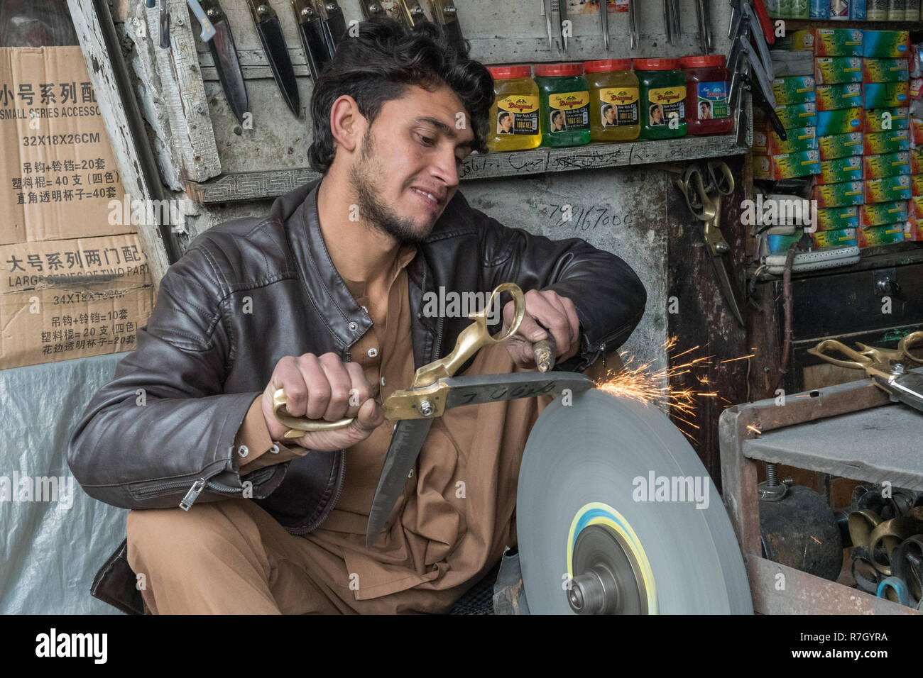 Les jeunes de l'affûteur de couteaux à Kaboul's Bazaar, Kaboul, province de Kaboul, Afghanistan Banque D'Images
