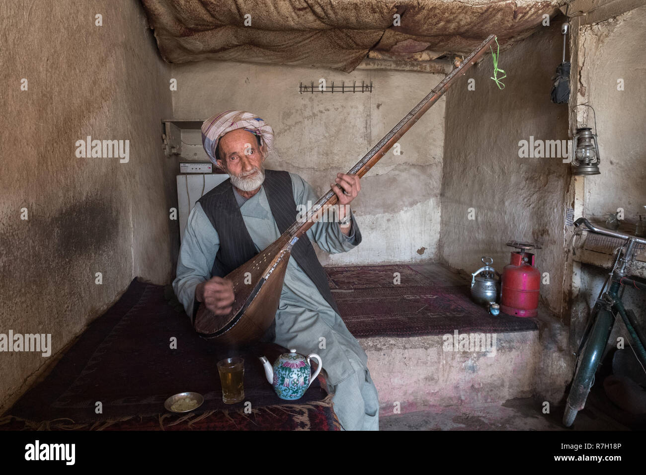 Vieil homme jouant rabab, l'instrument de musique nationaux afghans, dans une ancienne maison de thé vieux bazar, Herat, province de Herat, Afghanistan Banque D'Images