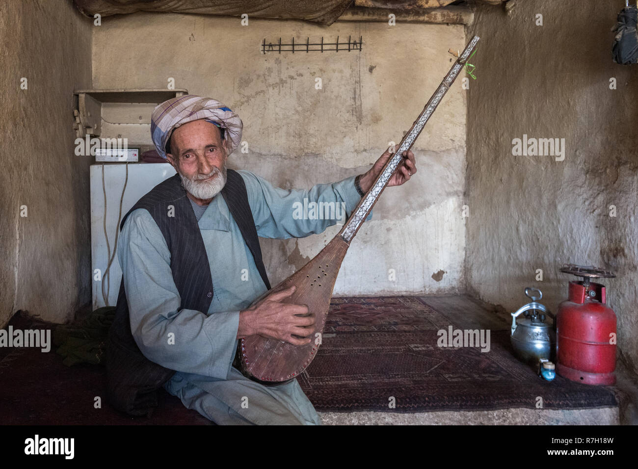 Vieil homme jouant rabab, l'instrument de musique nationaux afghans, dans une ancienne maison de thé vieux bazar, Herat, province de Herat, Afghanistan Banque D'Images