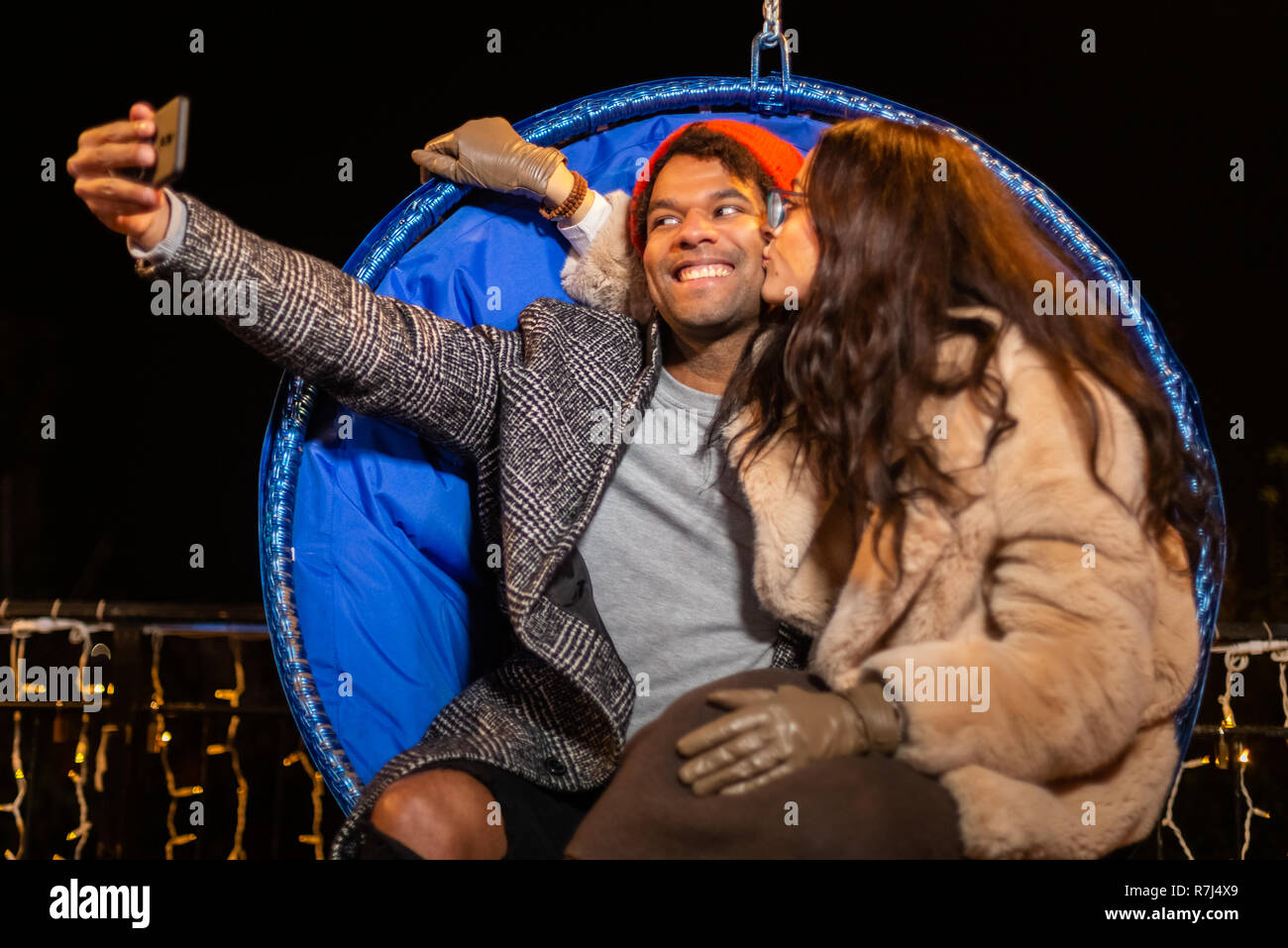 Couple assis sur chaise et prenant à selfies Marché de Noël, Zagreb, Croatie. Banque D'Images