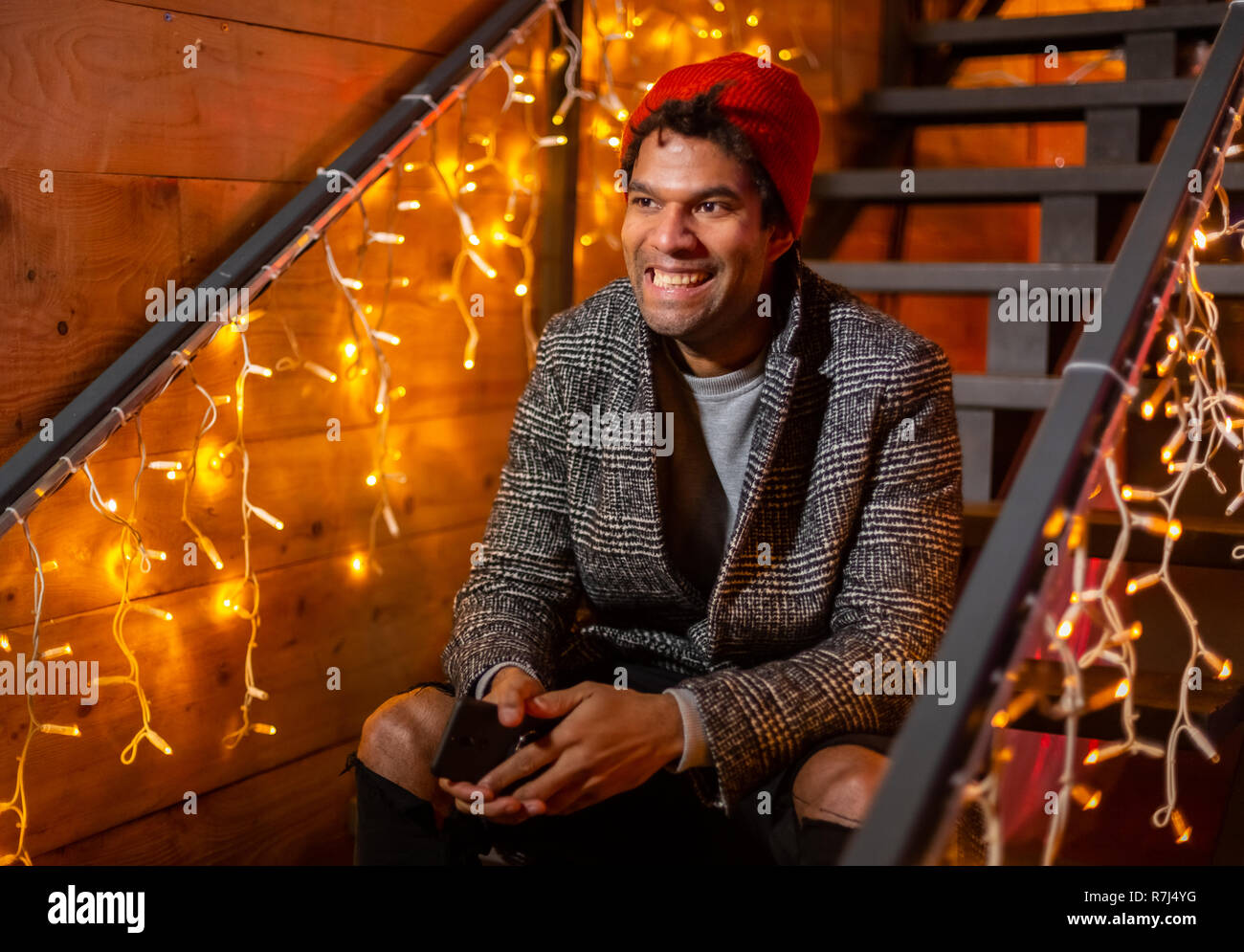 Portrait of african american man sitting on stairs et rire au marché de Noël, Zagreb, Croatie. Banque D'Images