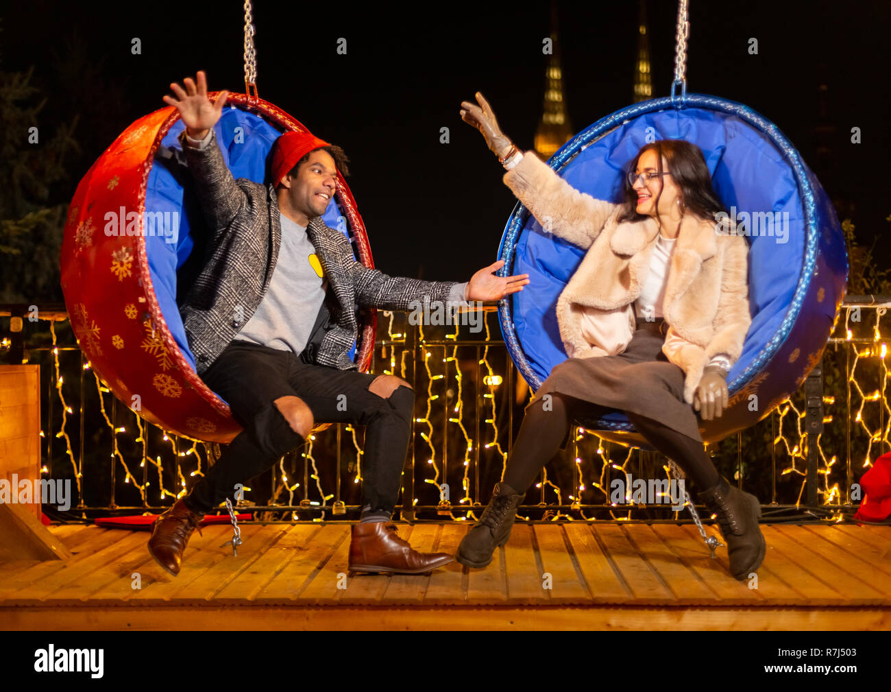 Couple pose pour photo sur balançoire au marché de Noël, Zagreb, Croatie. Banque D'Images