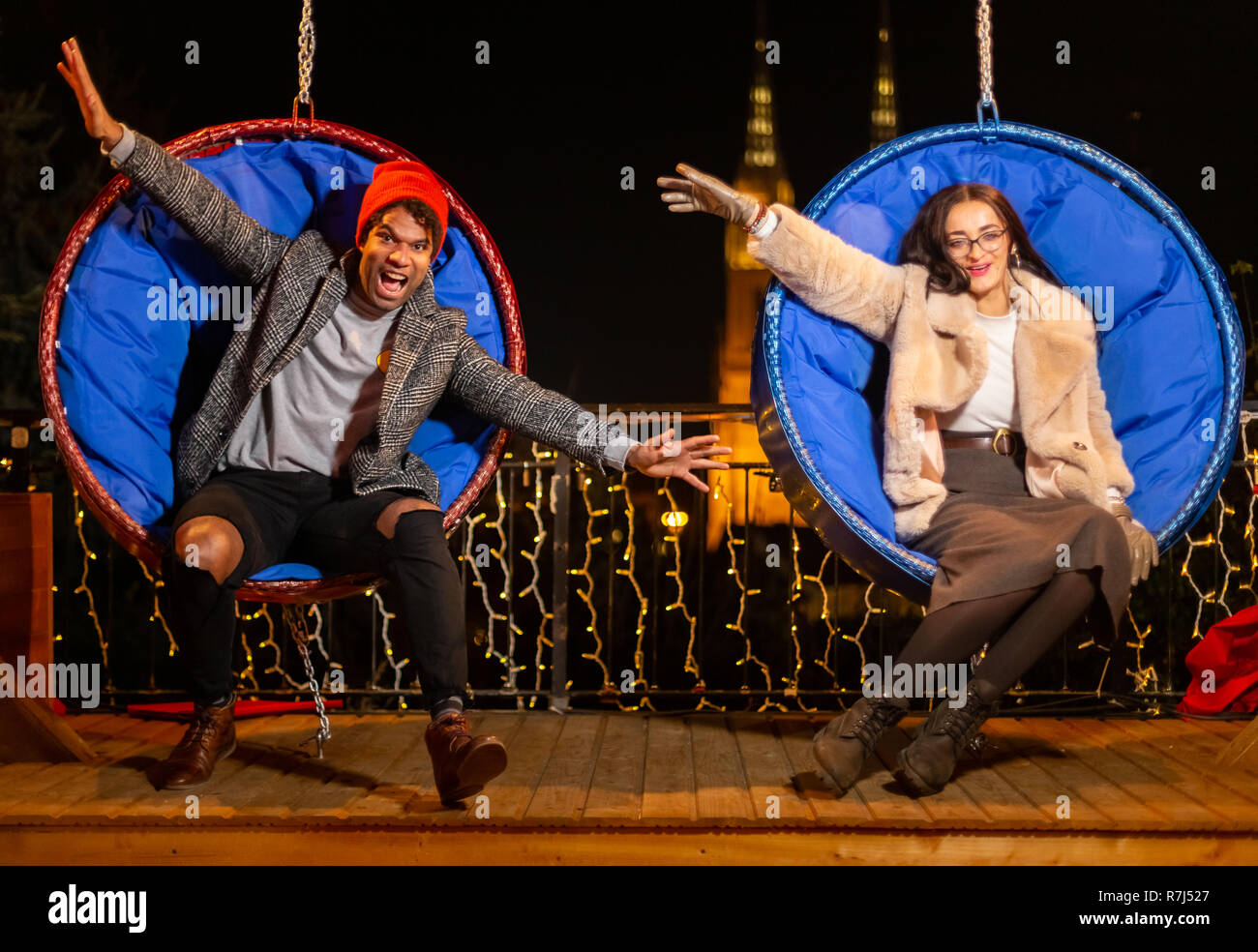 Couple pose pour photo sur balançoire au marché de Noël, Zagreb, Croatie. Banque D'Images