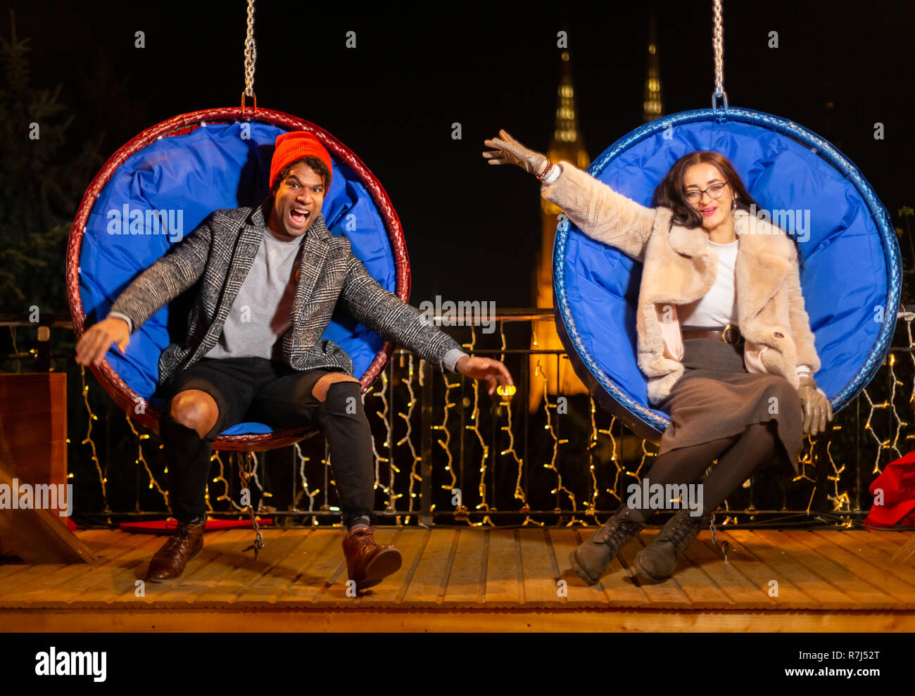 Couple pose pour photo sur balançoire au marché de Noël, Zagreb, Croatie. Banque D'Images