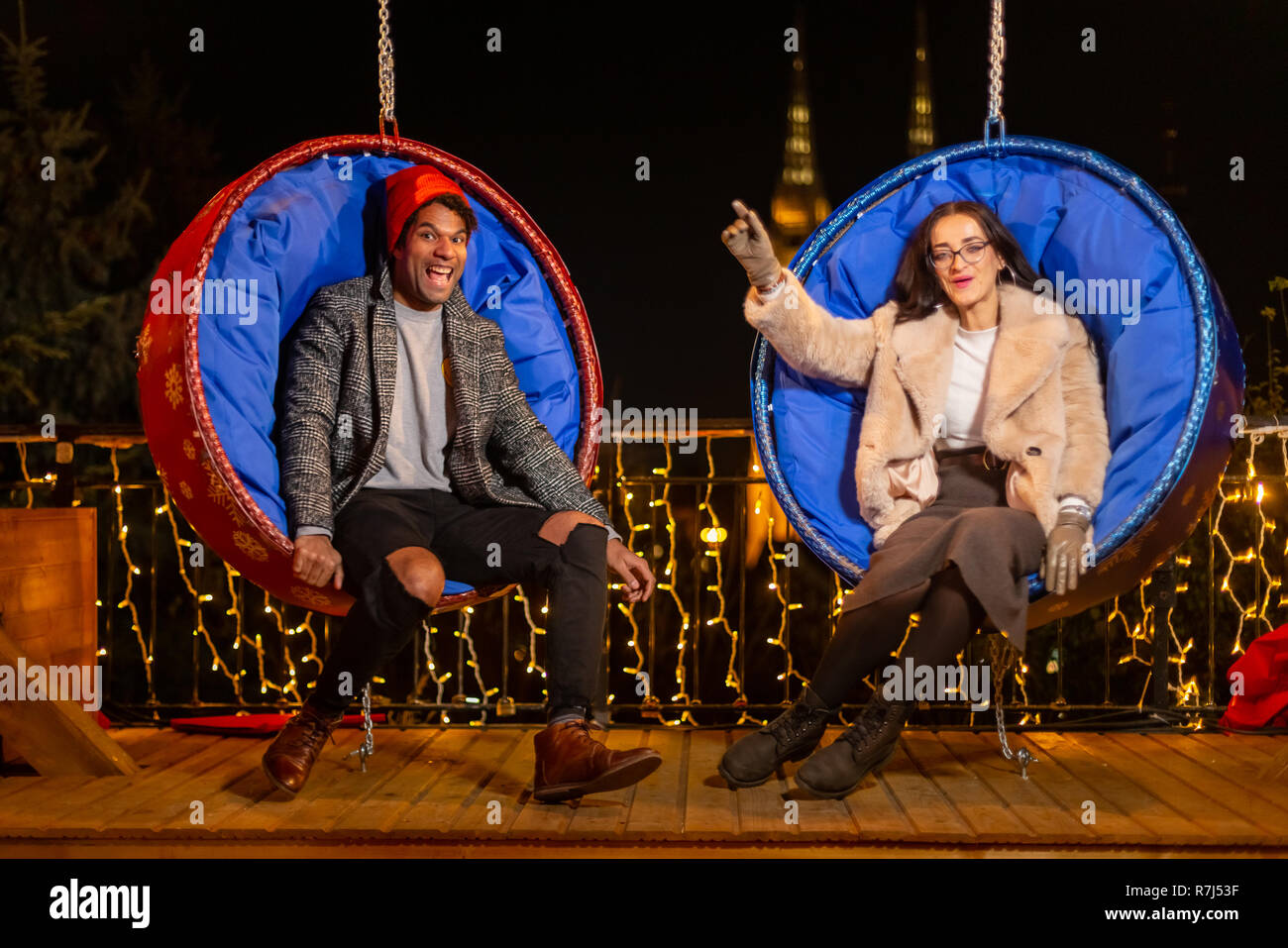 Couple pose pour photo sur balançoire au marché de Noël, Zagreb, Croatie. Banque D'Images