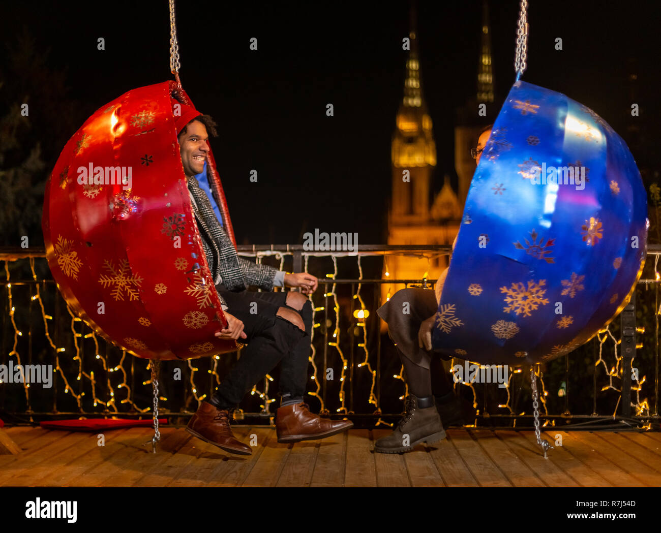 Couple sur la pendaison chaises Noël, Zagreb, Croatie. Banque D'Images