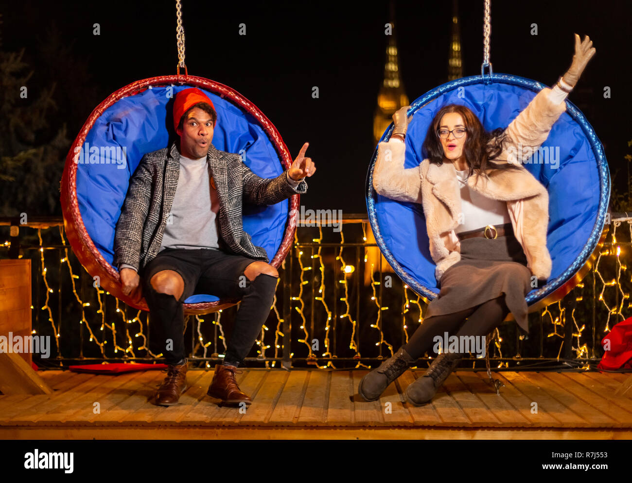 Couple sur la pendaison chaises Noël, Zagreb, Croatie. Banque D'Images