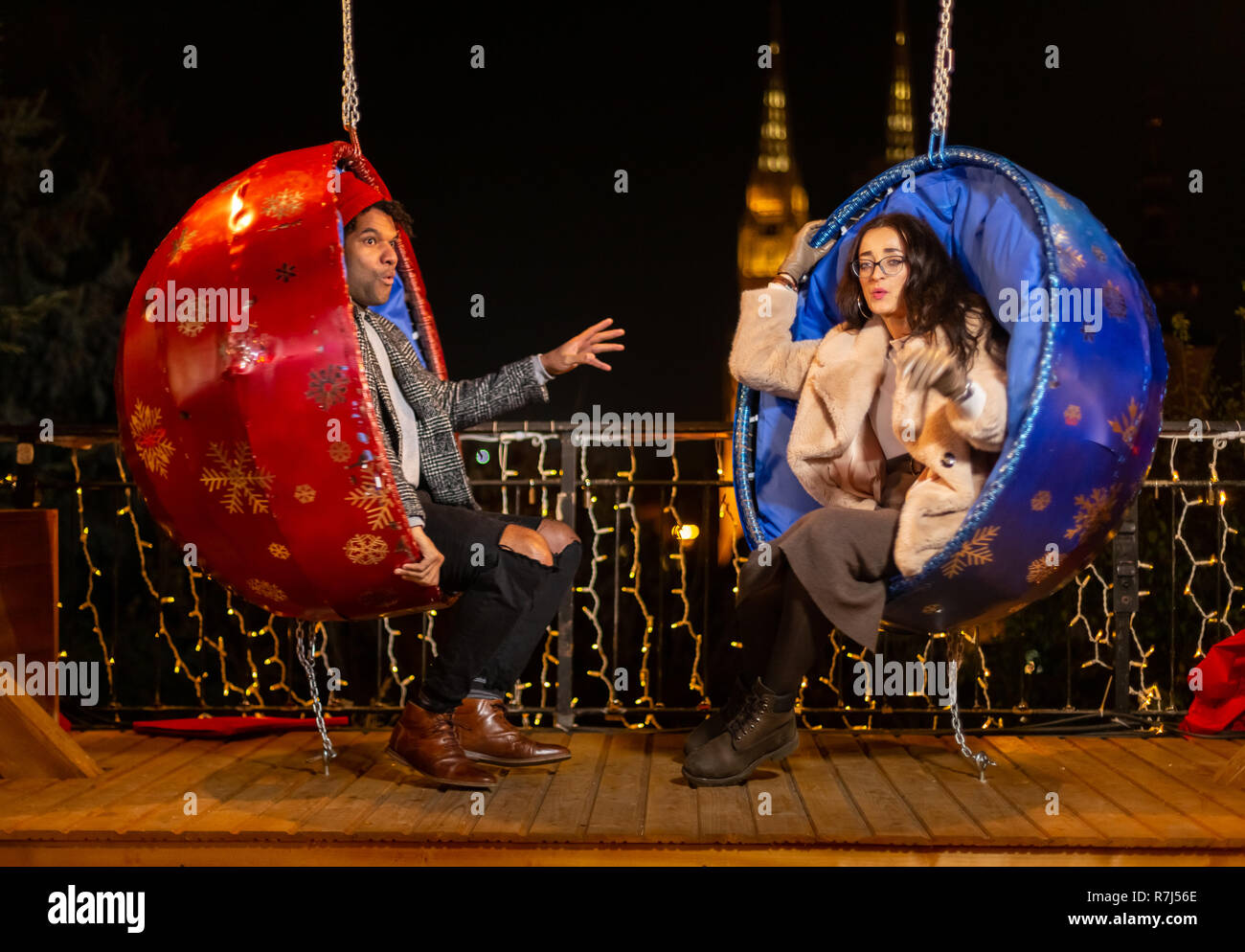 Couple sur la pendaison chaises Noël, Zagreb, Croatie. Banque D'Images