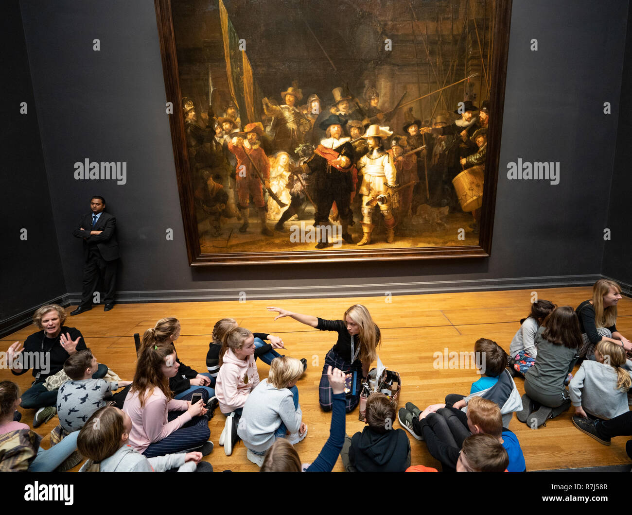 Les visiteurs à l'écoliers nuit regarder la peinture de Rembrandt van Rijn au Rijksmuseum à Amsterdam, Pays-Bas Banque D'Images
