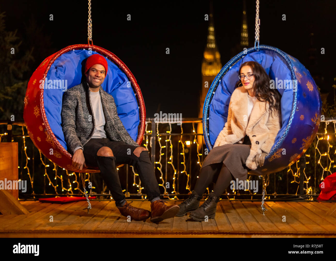 Couple posing sur la pendaison chaises Noël, Zagreb, Croatie. Banque D'Images