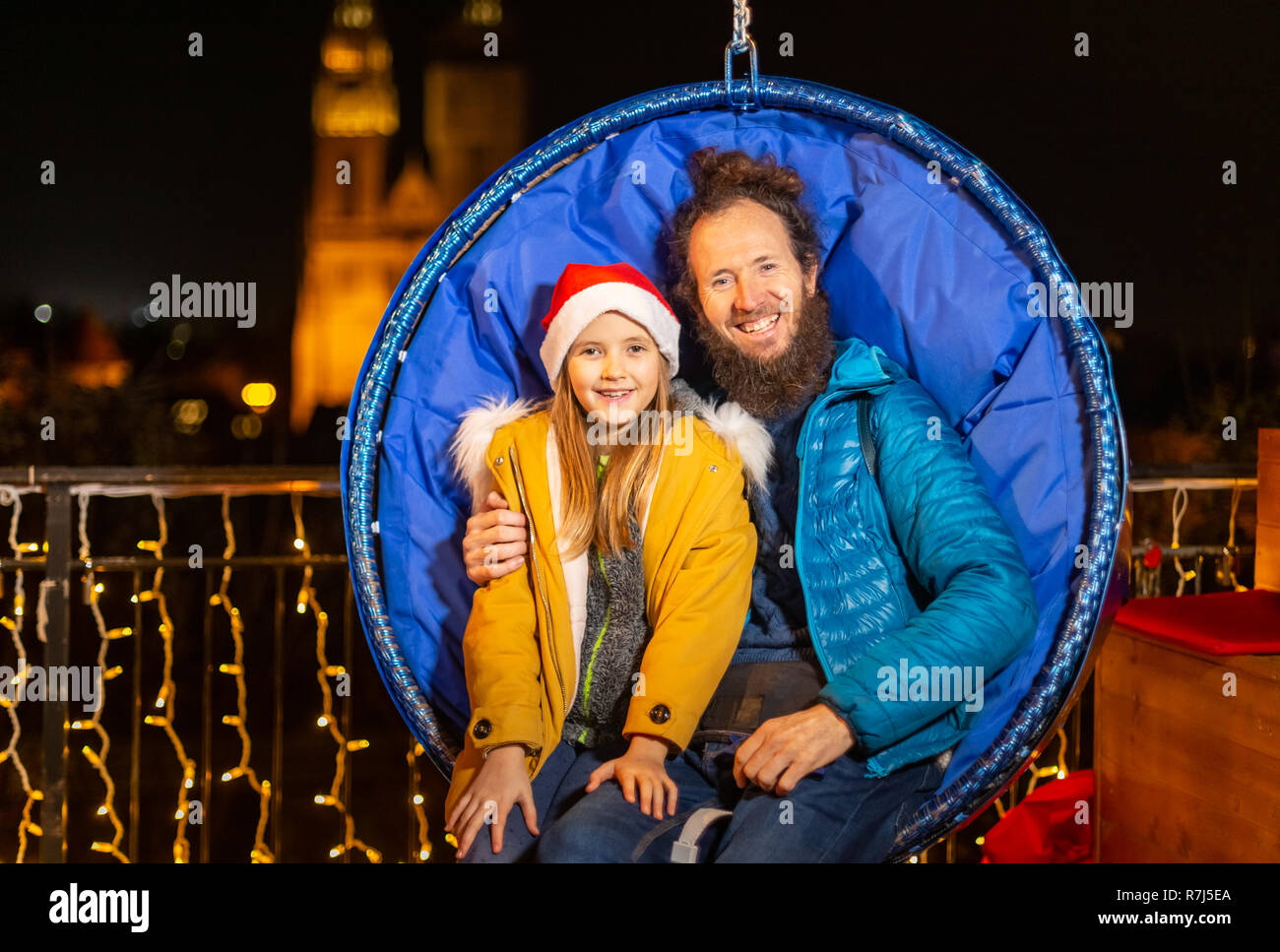 Père et fille assis sur des chaises de Noël suspendus, Zagreb, Croatie. Banque D'Images