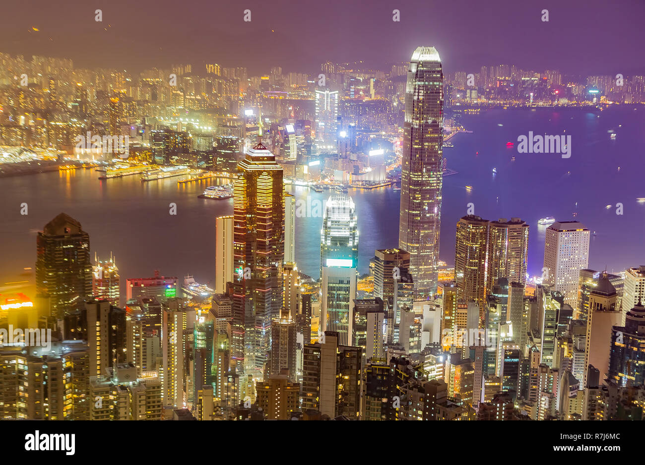 Hong Kong skyline at night vu depuis Victoria Peak. Gratte-ciel lumineux en premier plan, le port de Hong Kong en arrière-plan. Banque D'Images