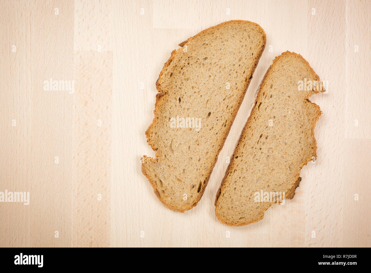 Deux tranches d'un pain typiquement allemand allongé sur une table en bois hêtre. Coup de gros plan ci-dessus. Ce pain est composé de 50 % de seigle. Il a une croûte croustillante. Banque D'Images