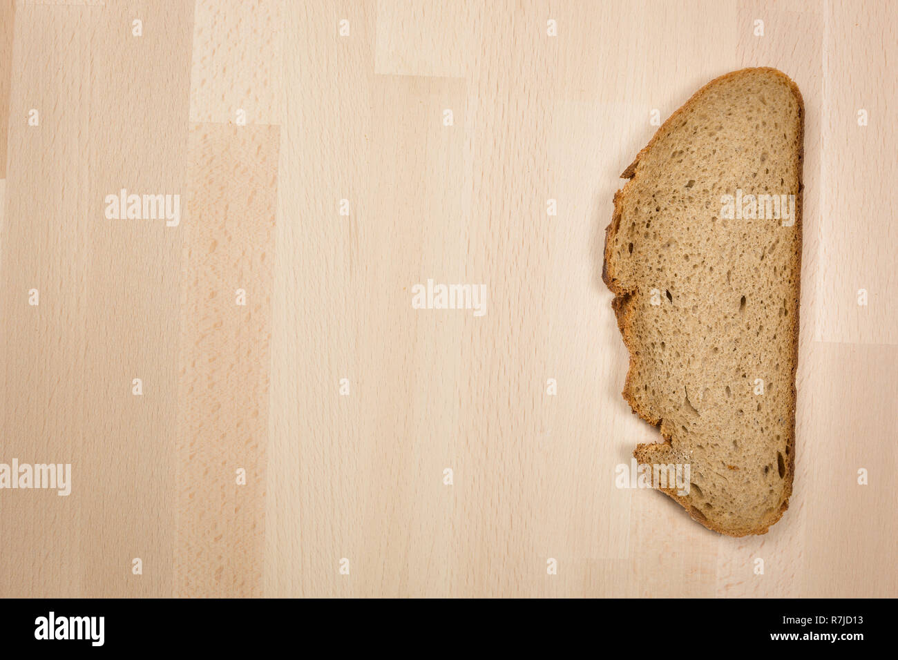 L'une des tranches de pain allemand typique allongé sur une table en bois hêtre. Coup de gros plan ci-dessus. Ce pain est composé de 50 % de seigle. Il a une croûte croustillante. Banque D'Images