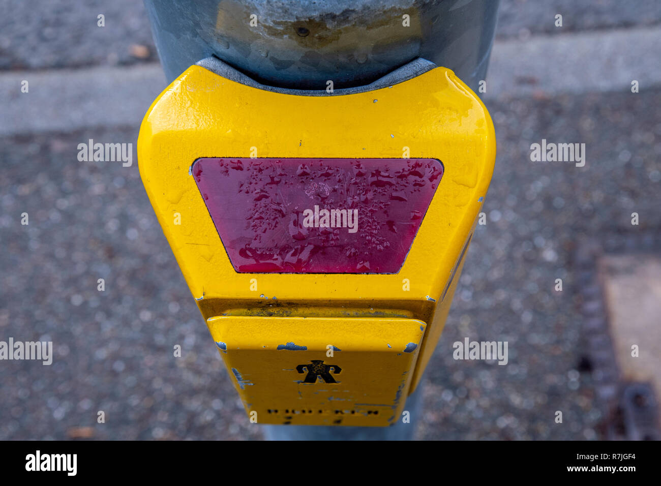 L'interrupteur de feux de circulation en jaune avec des gouttes à la rue Banque D'Images