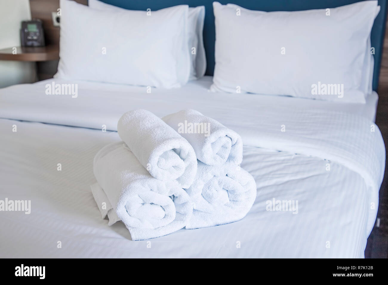 Des serviettes propres sur un lit blanc. Focus sélectionnée. Banque D'Images