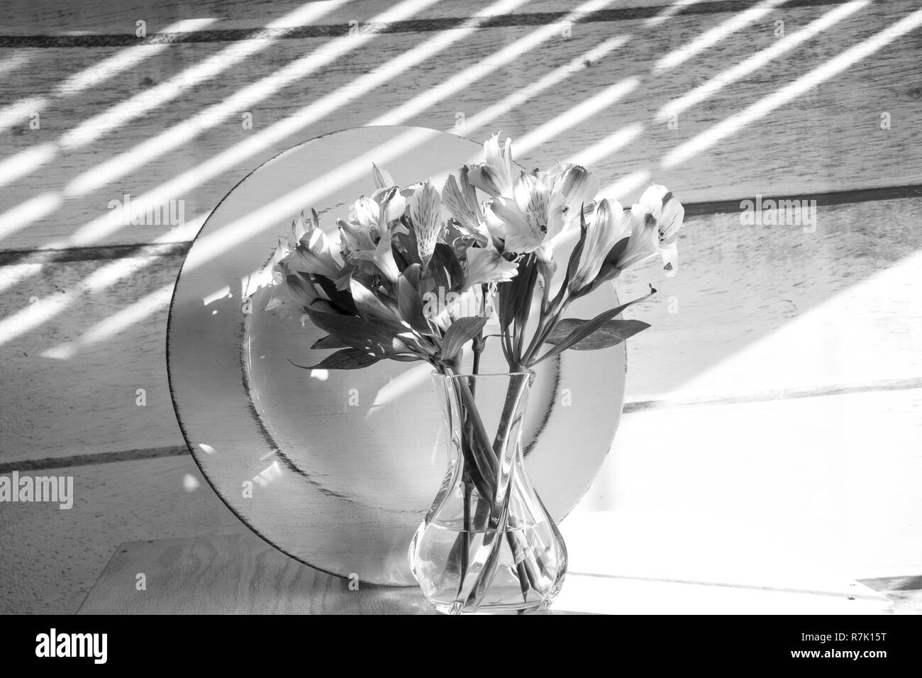 Un joli bouquet de fleurs coupées à l'avant d'une plaque sur une table en noir et blanc. Banque D'Images