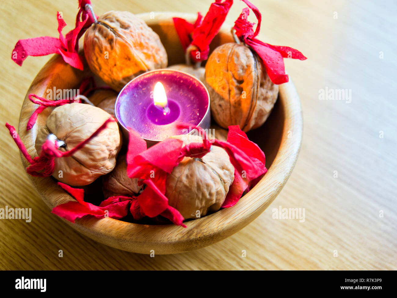 Bougie mauve décoré avec des noix dans un bol en bois. Pour Noël et Nouvel an chinois Banque D'Images