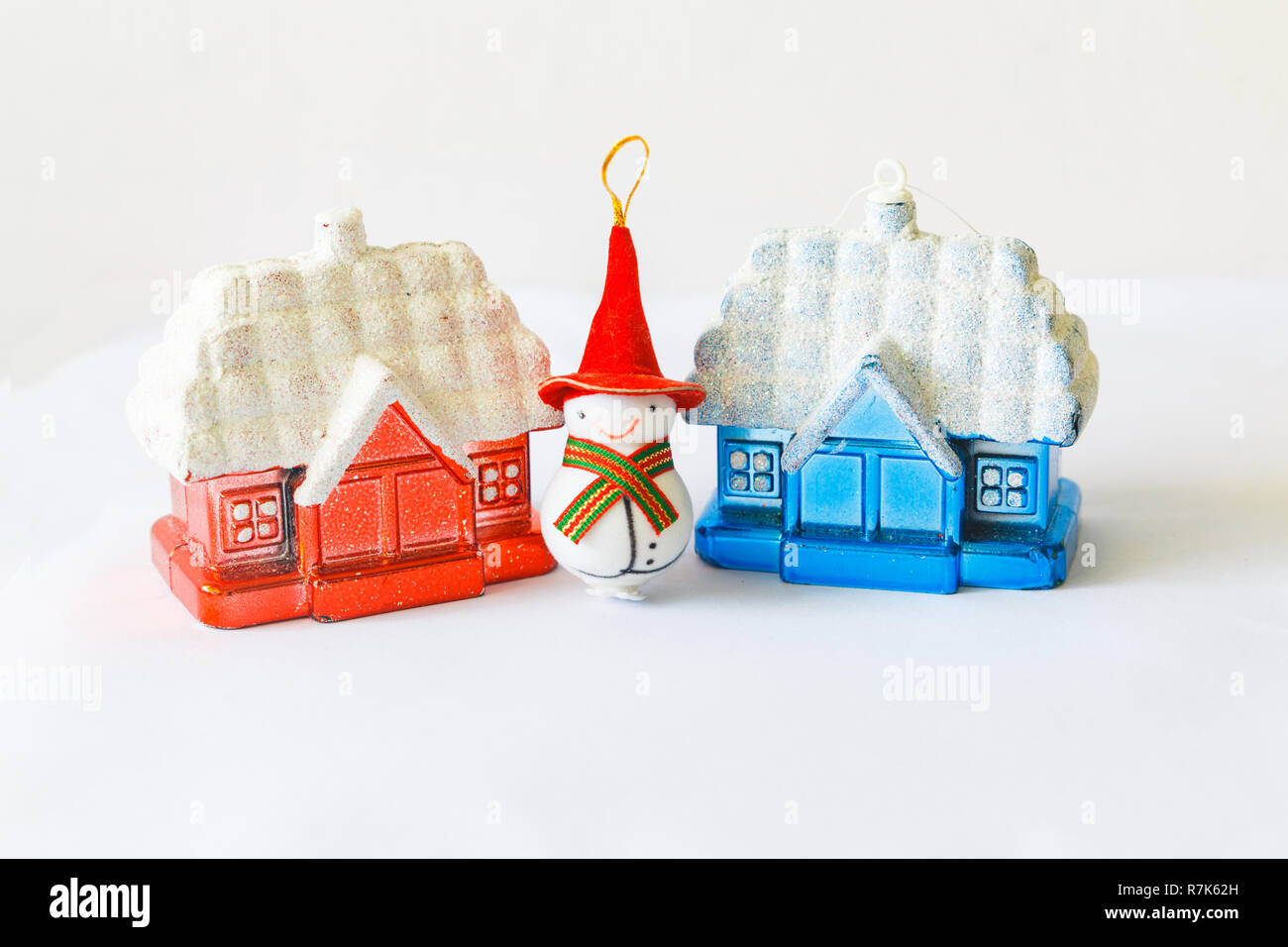 Les jouets du nouvel an. un bonhomme dans un grand bonnet rouge se situe entre les maisons rouge et bleu Banque D'Images