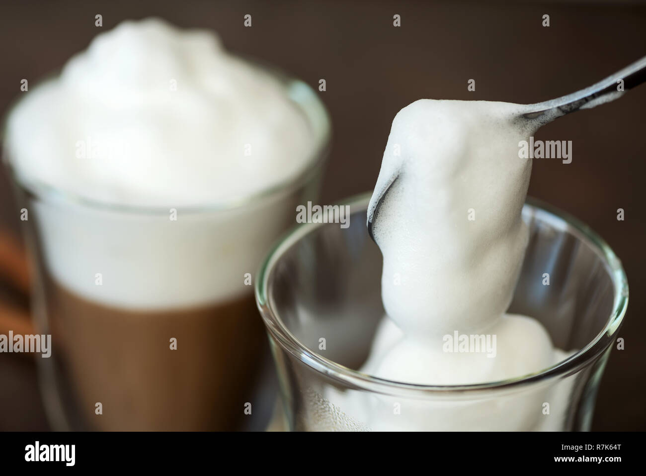 Mousse de lait est mis dans un verre de café. Banque D'Images