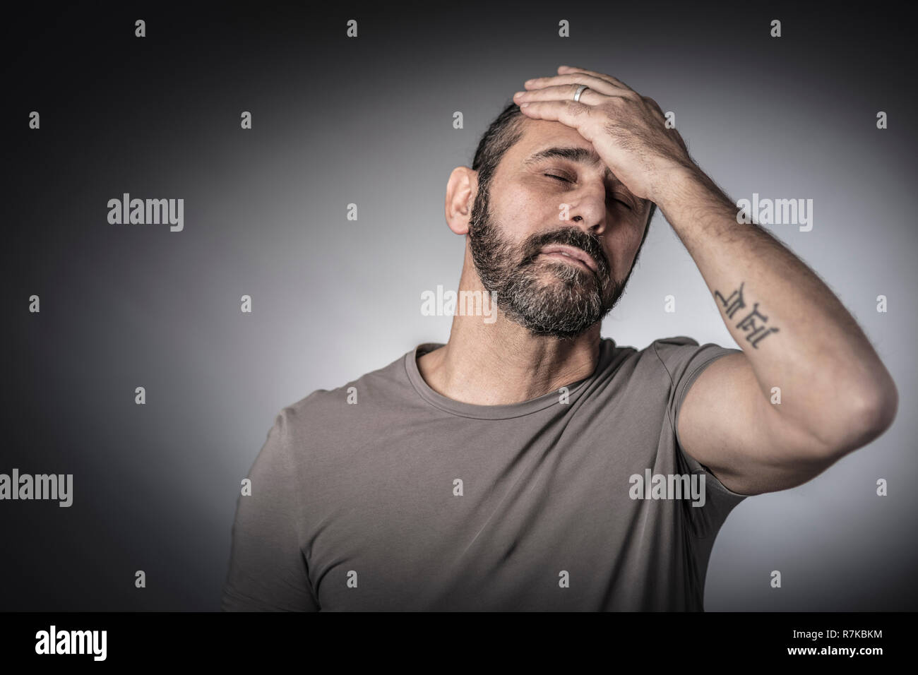 Fatigué barbu caucasienne cheveux longs homme studio portrait Banque D'Images