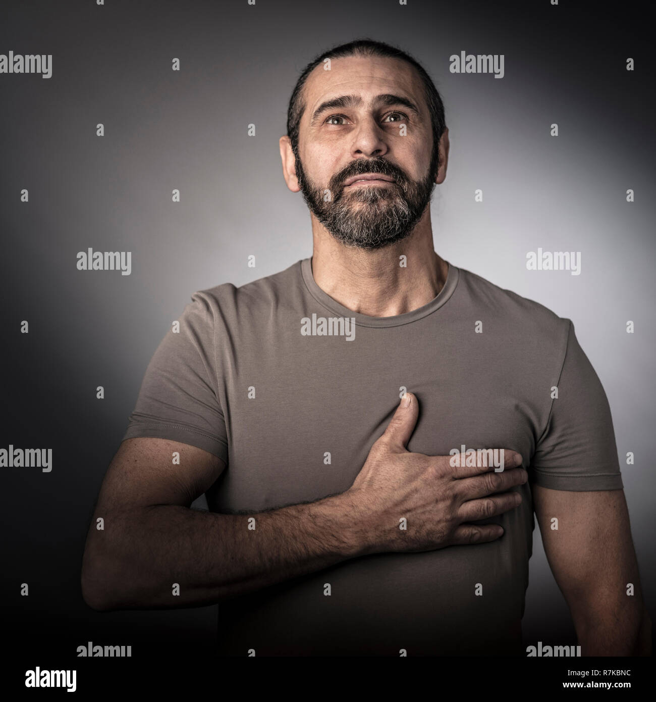 L'homme avec la main sur son coeur studio shot Banque D'Images