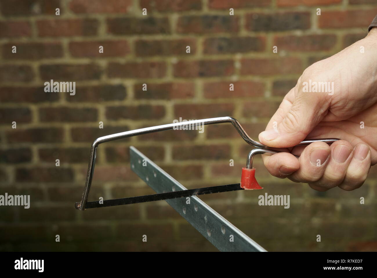 À l'aide d'une scie à métaux junior Banque D'Images