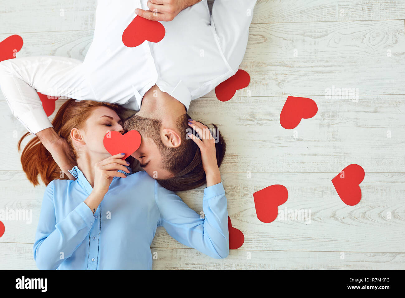 Bisous Couple allongé sur un étage avec un coeur de papier Banque D'Images