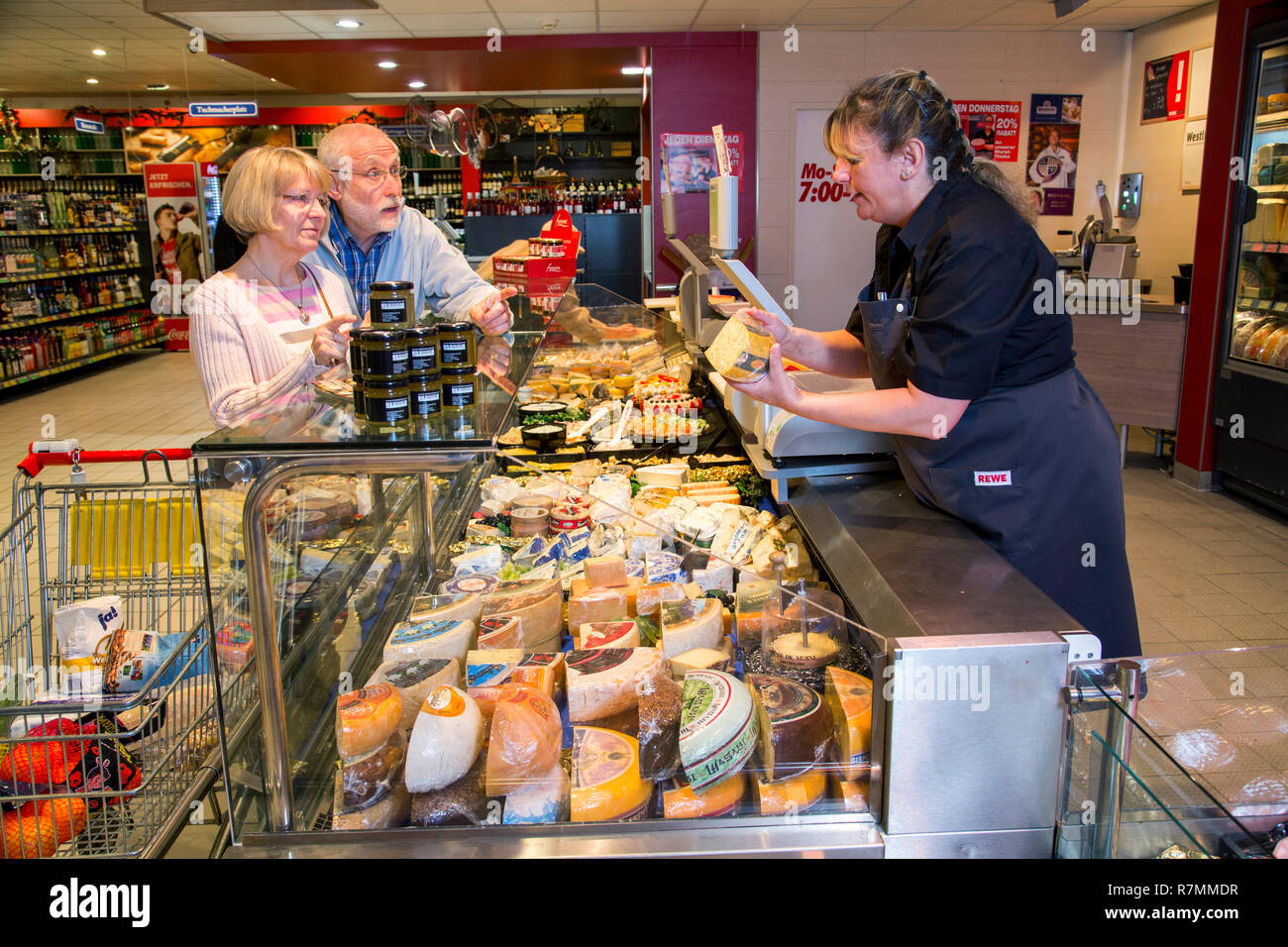 Shop assistant servant un couple au fromages, shopping dans un supermarché, Allemagne Banque D'Images