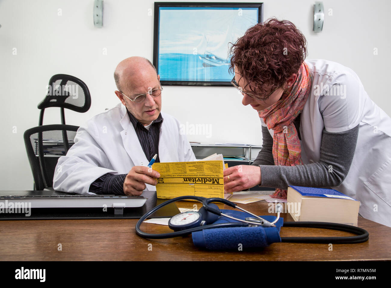 Bureau du médecin, l'assistant du médecin et médecin d'examiner les dossiers d'un patient ensemble, Allemagne Banque D'Images