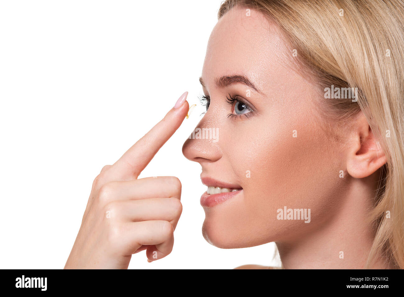 Jeune femme tenant sur lentilles de contact index avec l'exemplaire de l'espace. Close up face d'une magnifique femme qui à porter des lentilles de contact. Banque D'Images