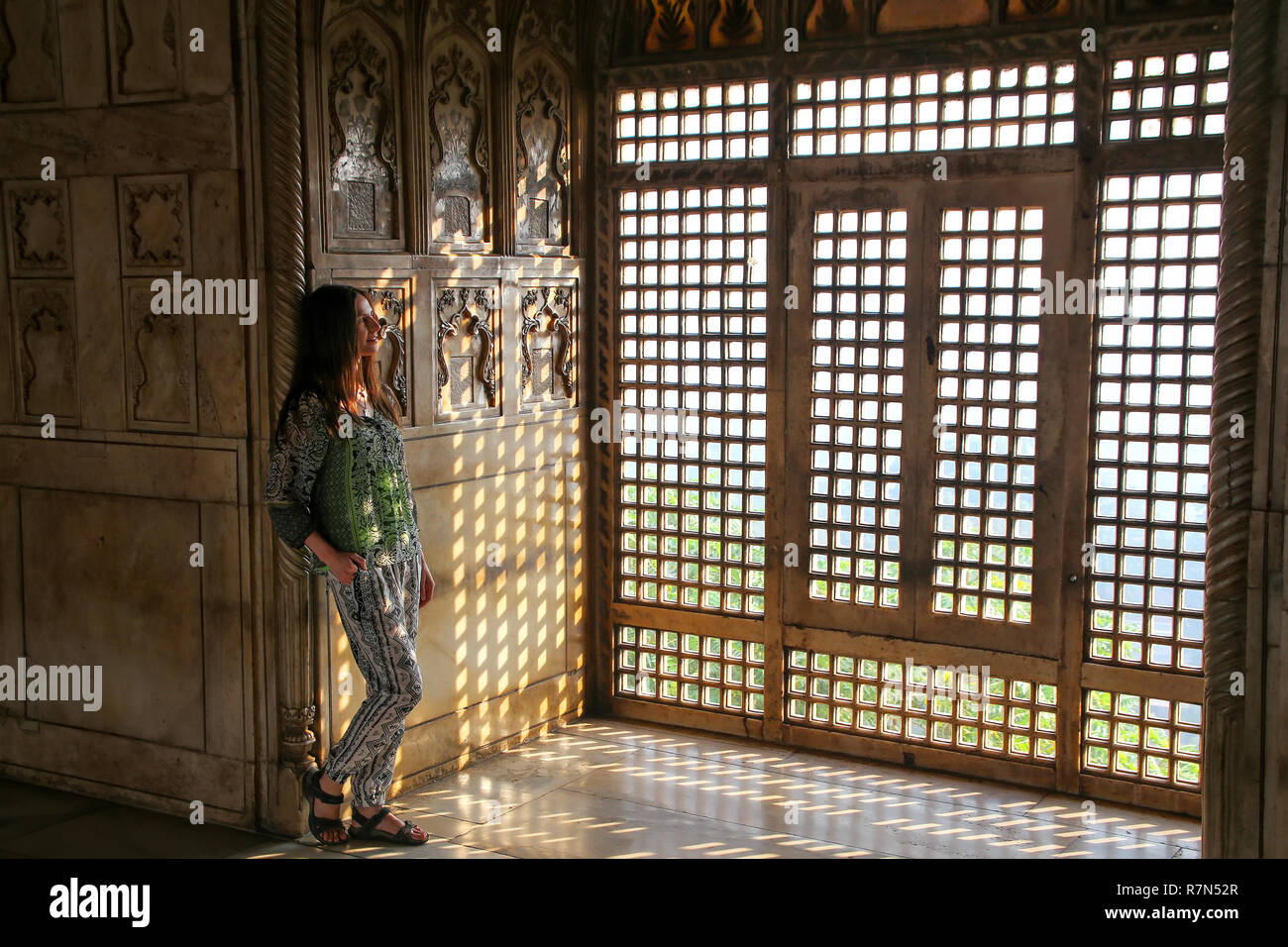 Jeune femme debout près de la fenêtre dans Khas Mahal, Fort d'Agra, Uttar Pradesh, Inde. Le fort a été construit principalement comme une structure militaire, mais a été plus tard Banque D'Images