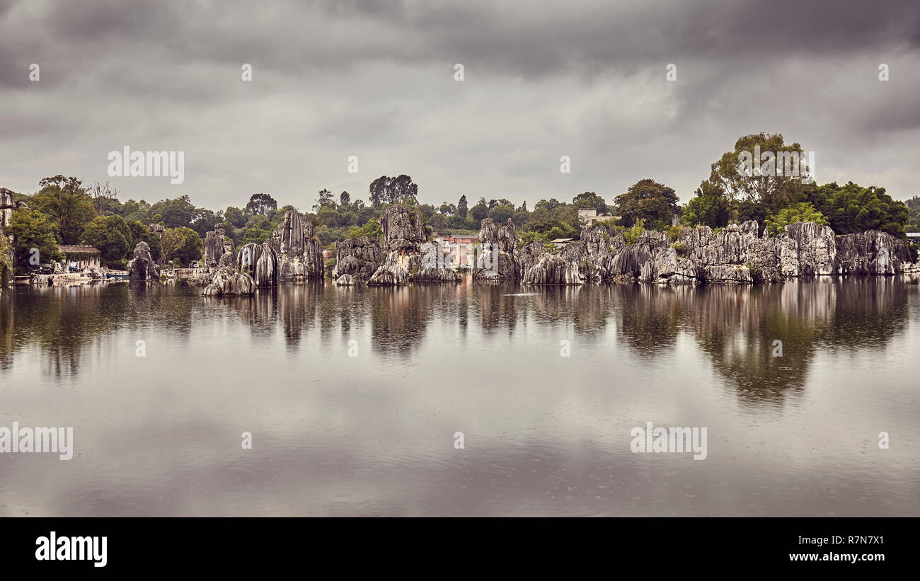 Forêt de pierre de Shilin formations calcaires reflété dans le lac un jour de pluie, rétro, colorés de la Chine. Banque D'Images