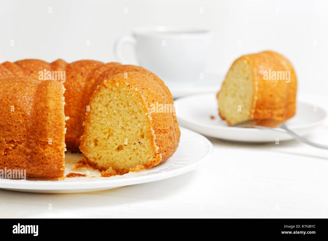 Ronde Maison Gateau Au Citron Imbibe De Sirop De Citron Sur La Table En Bois Blanc Le Morceau Coupe Et Une Tasse De The Sur Fond Flou L Accent Peu Profondes Photo Stock