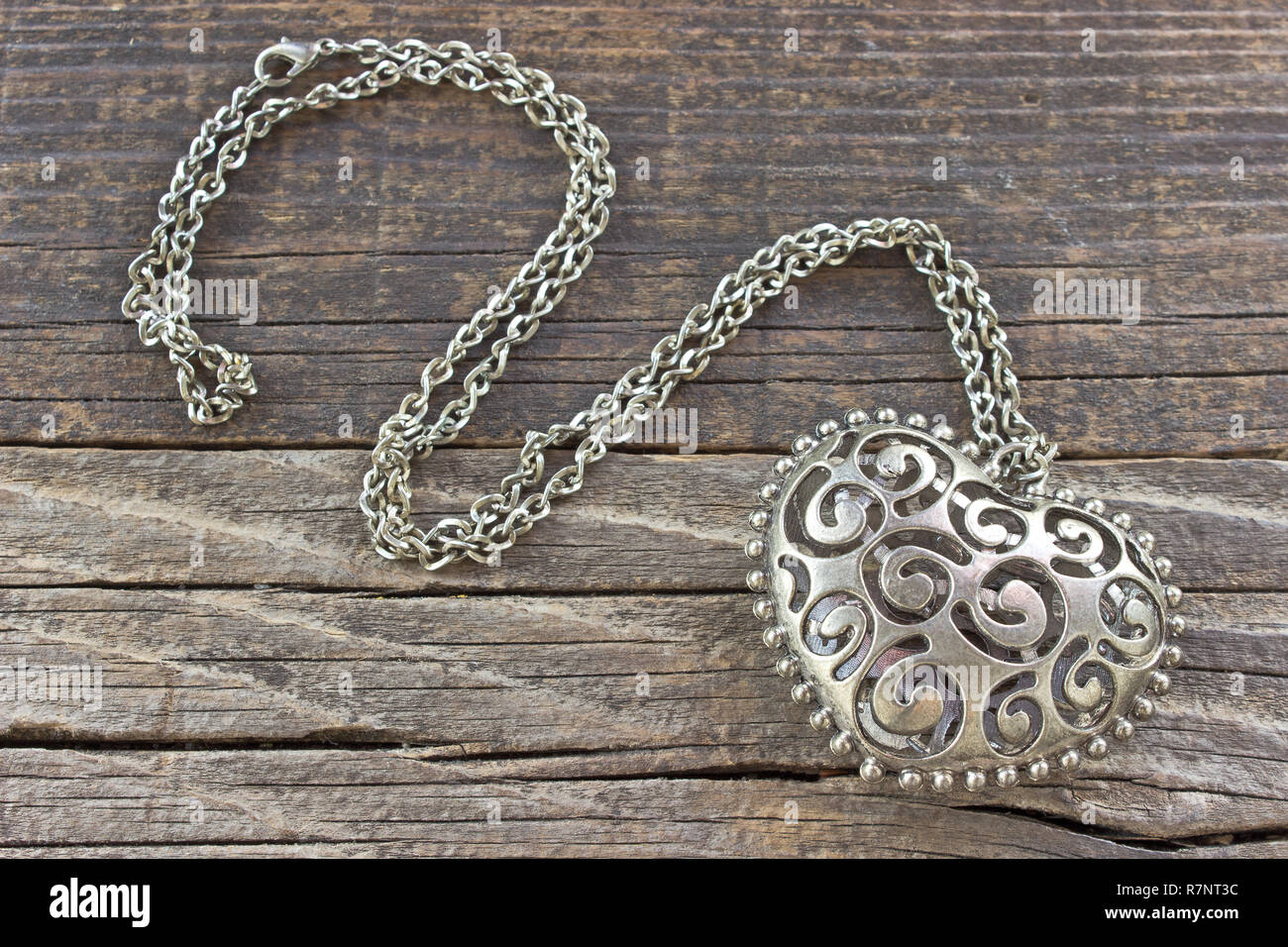 Collier argenté avec pendentif Coeur sur fond de bois Banque D'Images