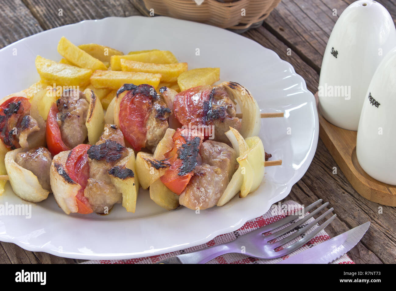 La viande grillée avec des légumes sur des bâtons dans la plaque sur la table Banque D'Images