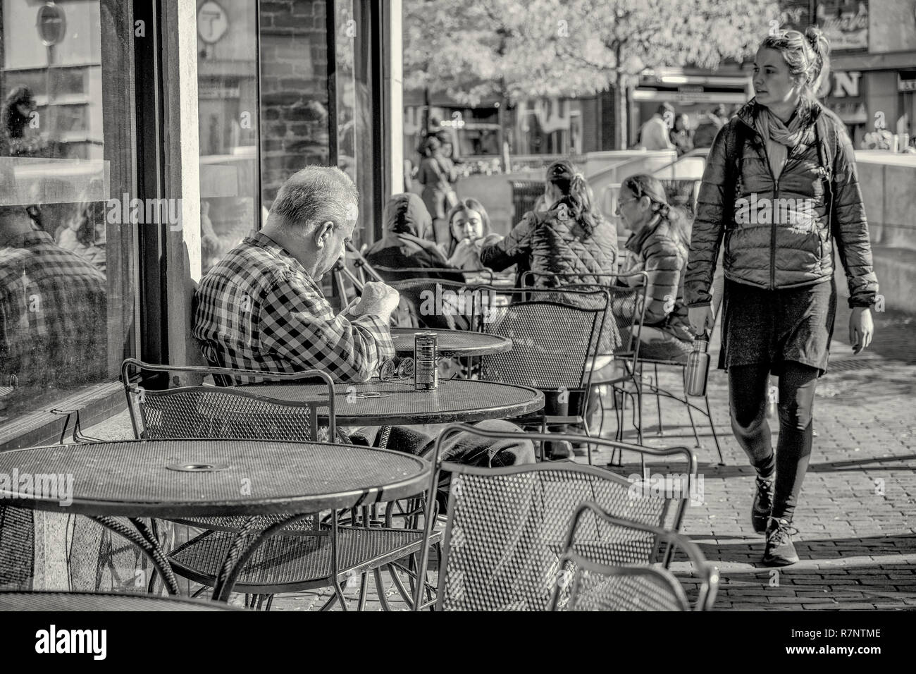 L'homme en utilisant son téléphone mobile à un café en plein air Banque D'Images