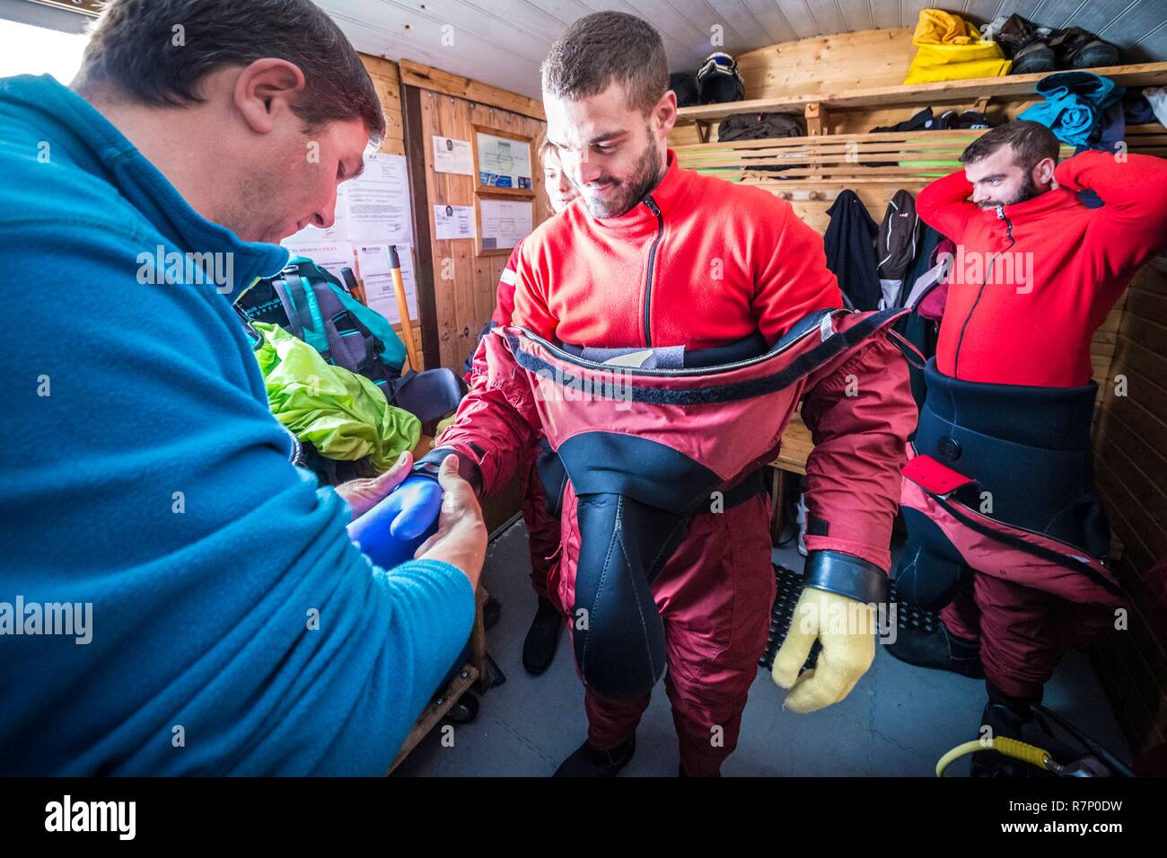 France, Isère (38), Belledonne, Chamrousse, Lacs Robert, après la paire de gants de laine pour garder les mains à bonne température, un instructeur vis la paire de gants étanches sur la combinaison, avant une glace plongée - Xtreme Banque D'Images