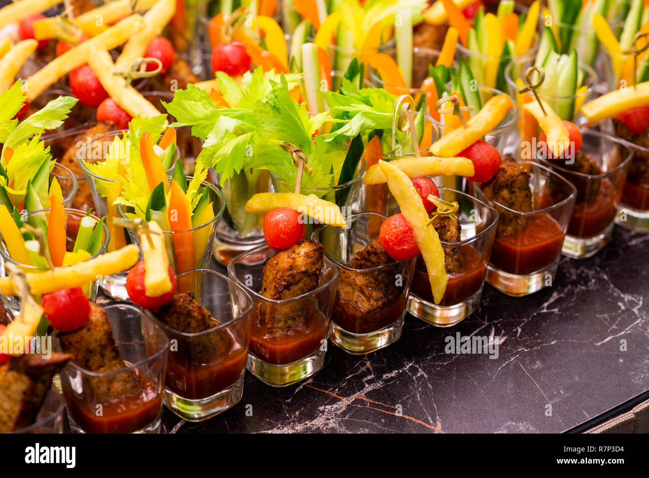 Des collations de viande avec des légumes dans une tasse en verre sur un plateau à la table du banquet Banque D'Images