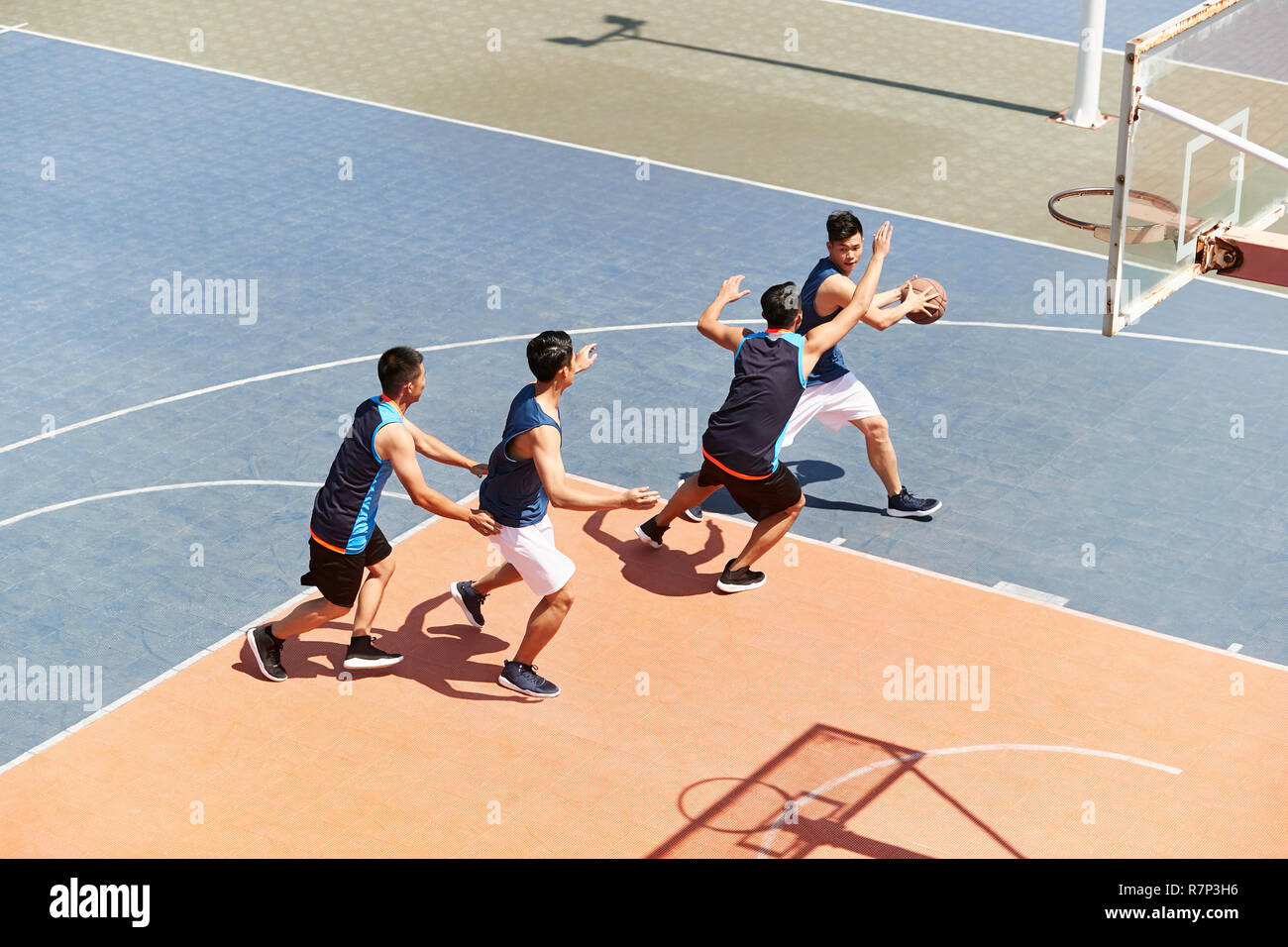 Les jeunes joueurs de basket-ball masculin asiatique jouant un jeu sur une cour. Banque D'Images