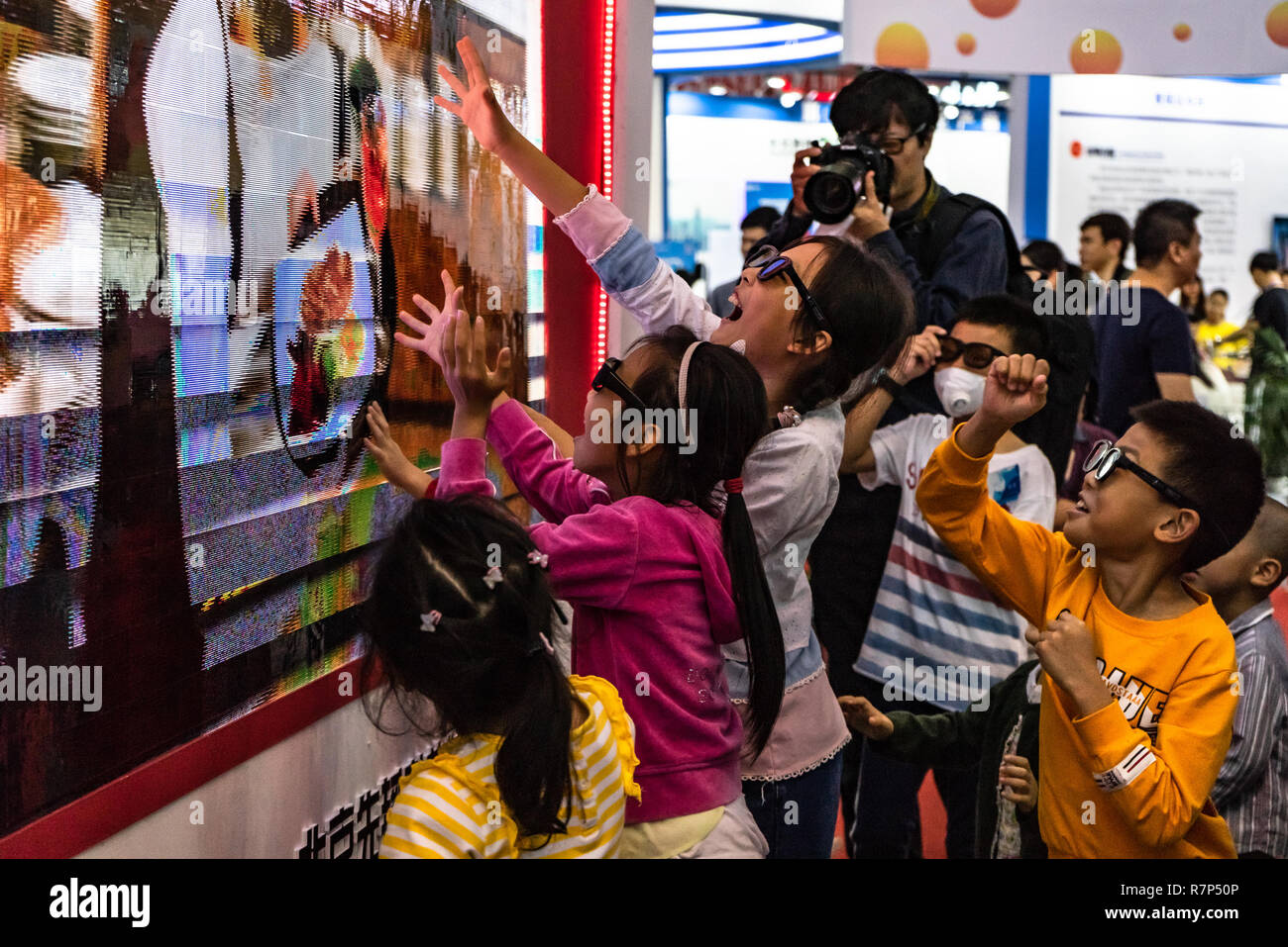 Les enfants portant des lunettes 3D et l'interaction avec des images sur un écran à la foire techno à Shenzhen, Chine Banque D'Images