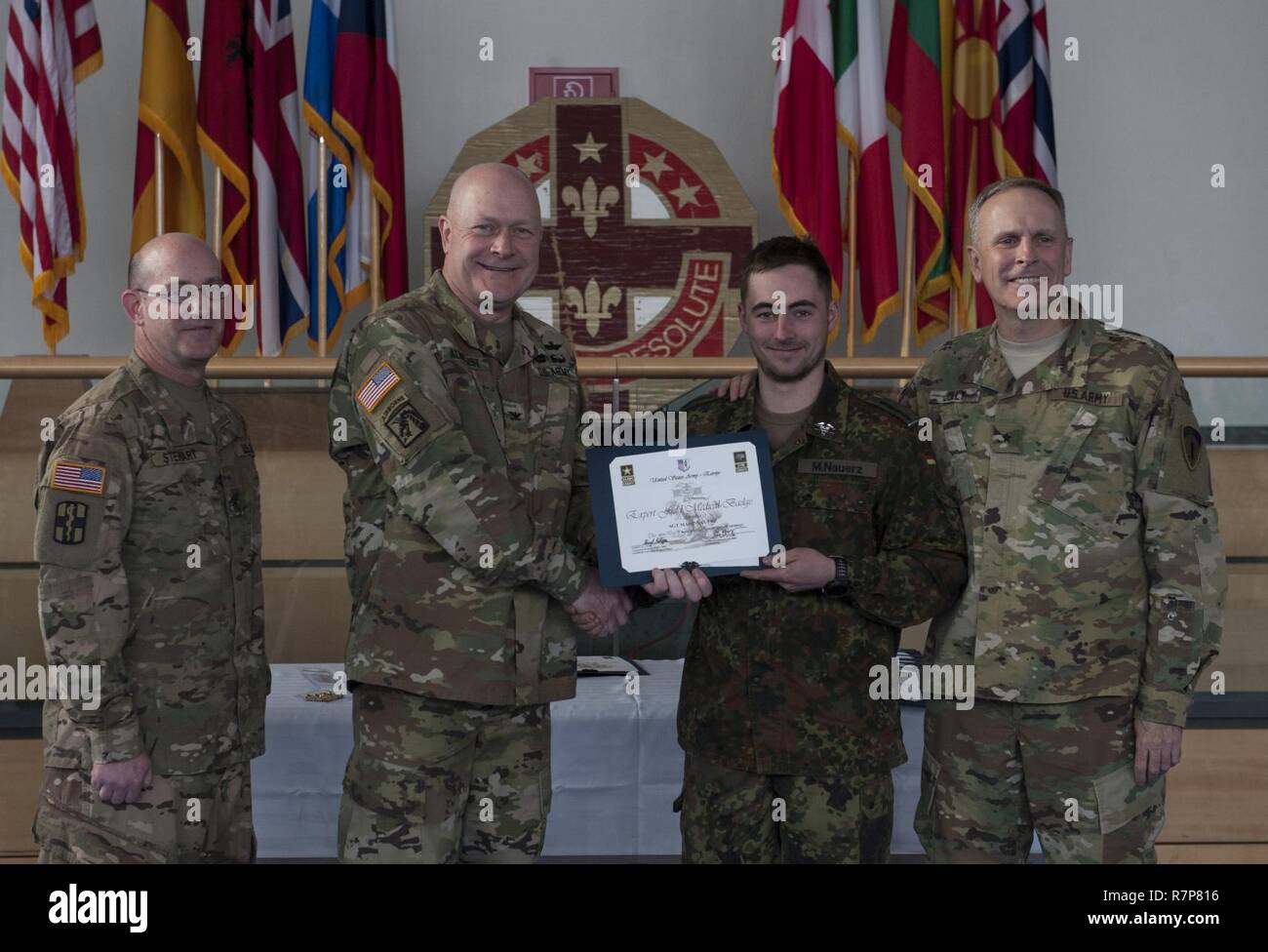 GRAFENWOEHR, Allemagne - Le Sergent Marc Nauerz (centre droit), un expert médical de l'Armée américaine sur le terrain Badge (EFMB) rapport avec l'armée allemande, reçoit un certificat d'achèvement de l'armée américaine le colonel Brian Almquist (centre gauche), commandant du 212e de l'Hôpital de soutien au combat, au cours d'une Europe de l'ARMÉE AMÉRICAINE EFMB Grafenwoehr en évaluation, en Allemagne le 30 mars 2017. Environ 215 candidats de l'armée américaine et européenne de dix pays partenaires ont participé à l'évaluation semestrielle dans l'espoir d'atteindre l'armée américaine convoitée EFMB mais seulement 64 l'ont reçu au cours de cette évaluation. Banque D'Images