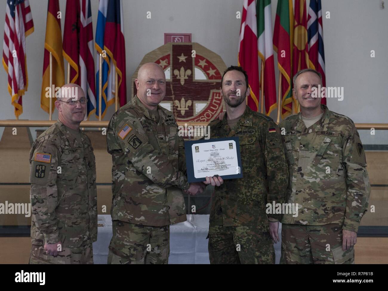 GRAFENWOEHR, Allemagne - Grand René Schliebener (centre droit), un expert médical de l'Armée américaine sur le terrain Badge (EFMB) destinataire avec l'armée allemande, reçoit un certificat d'achèvement de l'armée américaine le colonel Brian Almquist (centre gauche), commandant du 212e de l'Hôpital de soutien au combat, au cours d'une Europe de l'ARMÉE AMÉRICAINE EFMB Grafenwoehr en évaluation, en Allemagne le 30 mars 2017. Environ 215 candidats de l'armée américaine et européenne de dix pays partenaires ont participé à l'évaluation semestrielle dans l'espoir d'atteindre l'armée américaine convoitée EFMB mais seulement 64 l'ont reçu au cours de cette évaluation. Banque D'Images